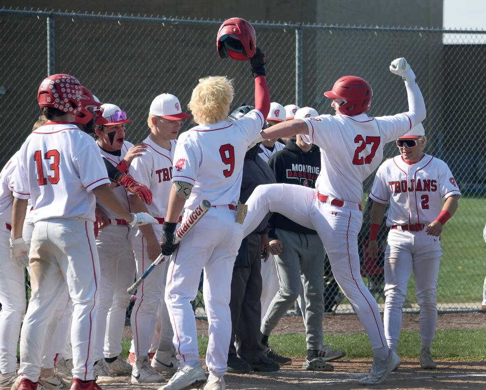 Freshman Asher Simmons of Monroe ready to stomp the home plate after hitting a grand slam home run greeted by his teammates against Bedford Monday, April 22, 2024.