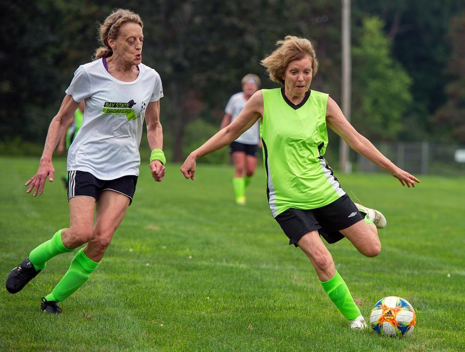 Dianne Baskind, of Framingham, pursued by Sue Zimmermann, of Lexington, at a Bay State Breakers practice  for women over 50 with some in their 70s at the Brophy School in Framingham, July 21, 2023. The women's over 65 team, which Baskind is a part of, made it to the championship game. The women's over 70 team won the championship for the second year in a row at the USASA Soccer Fest, a national over-30 tournament in Greensboro, NC.