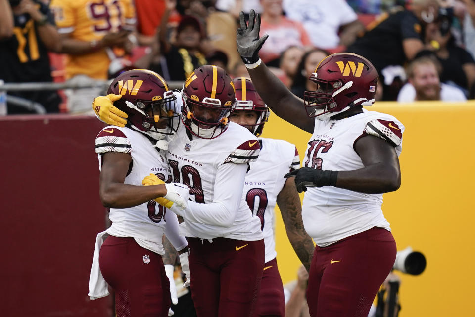 Washington Commanders wide receiver Mitchell Tinsley (86), left, celebrating his touchdown against the Cincinnati Bengals with teammate Marcus Kemp (19) and others during the first half of an NFL preseason football game, Saturday, Aug. 26, 2023, in Landover, Md. (AP Photo/Stephanie Scarbrough)