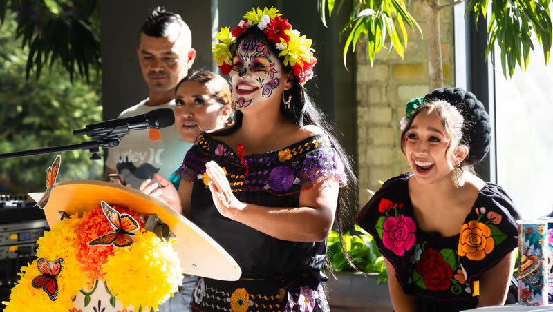 Left to right, Gabby Chavez and Jelcy Cruz clap during a performance at the annual Dia de Muerte celebration hosted by Una Mano Amiga at Historic Trolley Square in Salt Lake City on Saturday, Oct. 14, 2023.