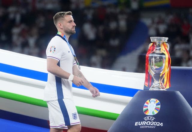 Luke Shaw walks past the Henri Delaunay Cup