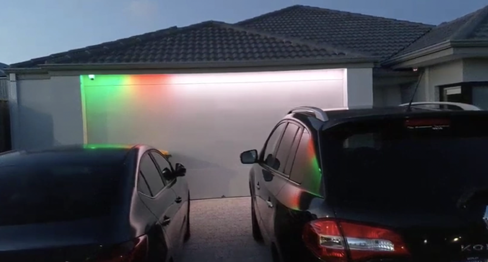 A Perth man's LED light display on his garage door, flashing green, reminding him to take out kitchen and other plant or animal wastes.the 