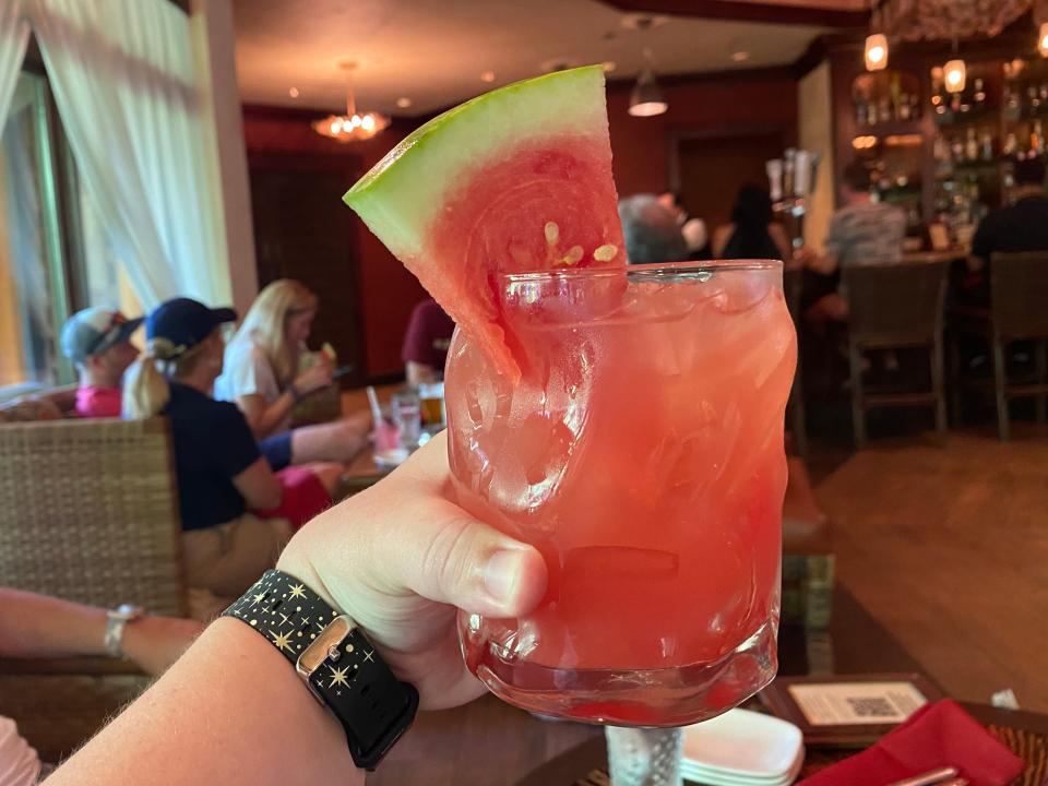 The writer holds a Hightower Rocks drink at Nomad Lounge