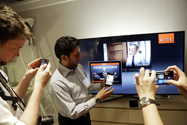 Suveer Kothari, center, displays how the new Chromecast device operates a television with the use of a smartphone. (AP Photo/Marcio Jose Sanchez)