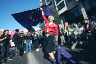 An anti-Brexit campaigner dressed as Theresa May waves European Union flags during the People's Vote March for the Future in London, a march and rally in support of a second EU referendum, in London, Saturday Oct. 20, 2018. Thousands of protesters gathered in central London on Saturday to call for a second referendum on Britain’s exit from the European Union. (Yui Mok/PA via AP)