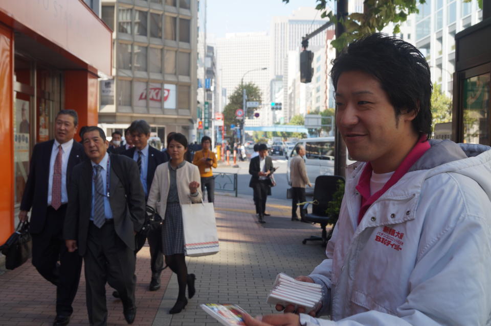 <p>Jyunya Takesue, 31, hands out packets of tissue featuring advertisements for a pachinko parlor in Shinbashi, Tokyo. “Yes, I’m concerned about North Korea developing a nuclear weapon and think that’s a threat to Japan. We have to strengthen self-defense, including SDF, and work with America,” Takesue said. (Photo: Michael Walsh/Yahoo News) </p>