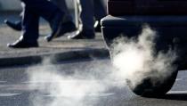 An exhaust pipe of a car is pictured on a street in a Berlin