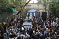 A vehicle carrying former Prime Minister Imran Khan is surrounded by his supporters as he leaves for Islamabad from his residence in Lahore, Pakistan, Saturday, March 18, 2023. A top Pakistani court on Friday suspended an arrest warrant for Khan, giving him a reprieve to travel to Islamabad and face charges in a graft case without being detained. (AP Photo/K.M. Chaudary)
