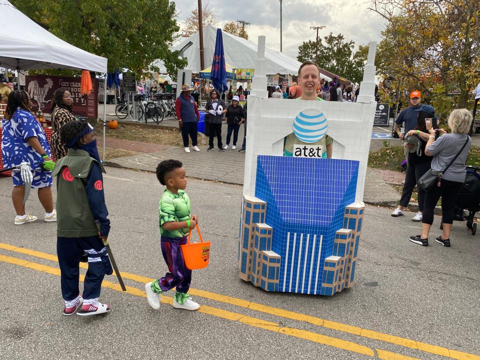 Children pass by Nate Moran's homemade Batman Building costume at All Hallows East in Nashville, Tenn. on Oct. 28, 2023.