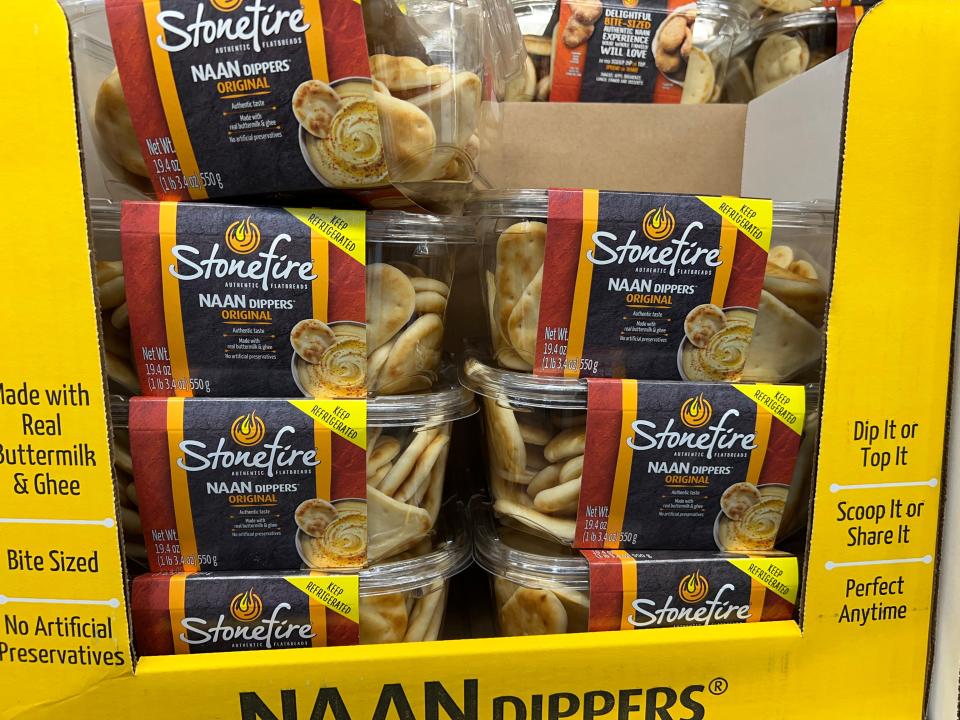 Clear plastic boxes of Stonefire mini naan dippers with red and black labels in a yellow cardboard box