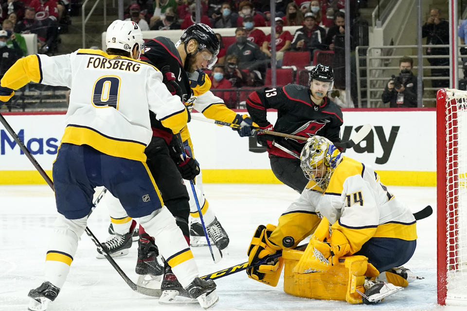 Nashville Predators left wing Filip Forsberg (9) and goaltender Juuse Saros (74) block Carolina Hurricanes center Jordan Staal as Hurricanes left wing Warren Foegele (13) watches during the second period in Game 5 of an NHL hockey Stanley Cup first-round playoff series in Raleigh, N.C., Tuesday, May 25, 2021. (AP Photo/Gerry Broome)