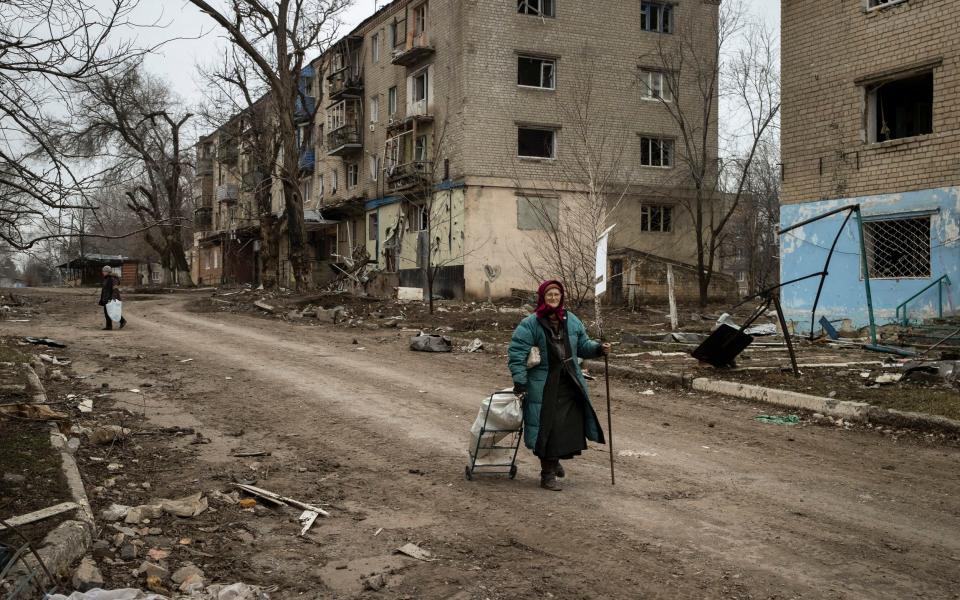 A civilian walks past destroyed buildings in Siversk, a city north of Bakhmut, in the Donetsk province of eastern Ukraine - Tyler Hicks/The New York Times
