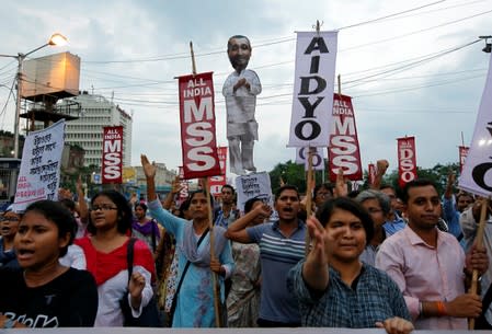 People shout slogans as they carry an effigy depicting Kuldeep Singh Sengar, a legislator of the ruling BJP, during a protest demanding justice for a woman who is fighting a rape case against the legislator in Kolkata