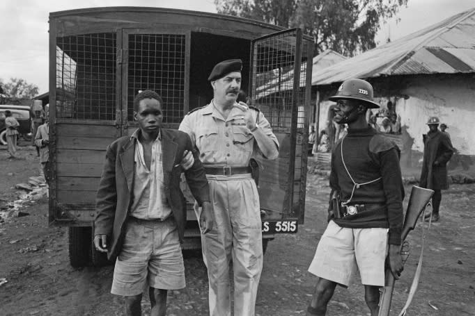 Police officers of the Kenya Police arrest a teenage boy in a Nairobi neighbourhood during the Mau Mau Uprising, 1956. Original Publication: Picture Post - 8232 - Nairobi Police - unpub. 1956. 