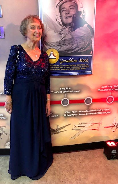 Susan Reid stands with a photo of her sister at Jerrie Mock’s enshrinement in the National Aviation Hall of Fame on Sept. 24, 2022, in Dayton at the Air Force Museum.