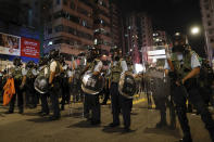 Policemen in riot gear stand on a street as they confront protesters in Hong Kong, Wednesday, Aug. 14, 2019. German Chancellor Angela Merkel is calling for a peaceful solution to the unrest in Hong Kong amid fears China could use force to quell pro-democracy protests. (AP Photo/Vincent Yu)