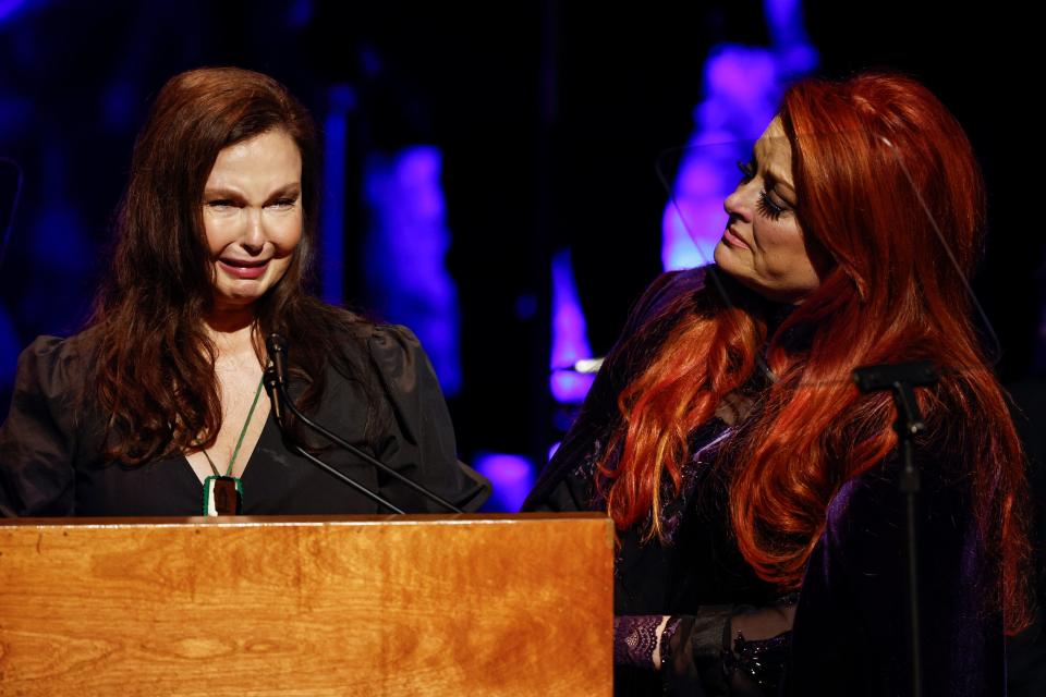 Ashley Judd, left, cries, as she speaks as sister Wynonna Judd, watches during the Medallion Ceremony at the Country Music Hall of Fame.