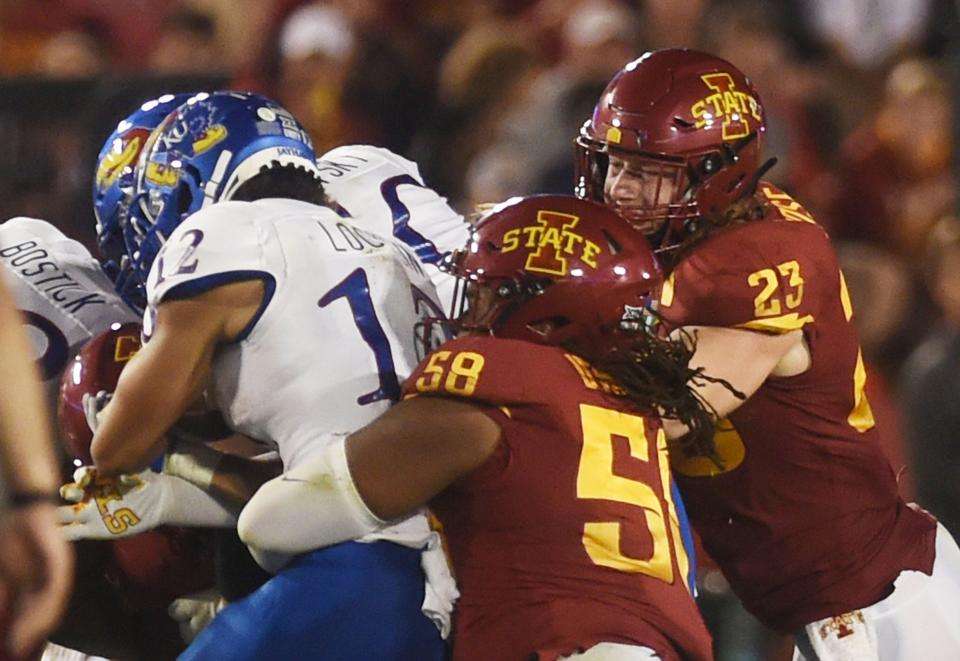 Cyclones linebacker Mike Rose and defensive end Eyioma Uwazurike take down Kansas wide receiver Torry Locklin.