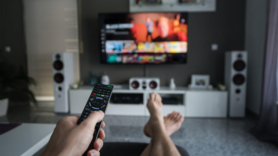 person sat with their feet up watching television