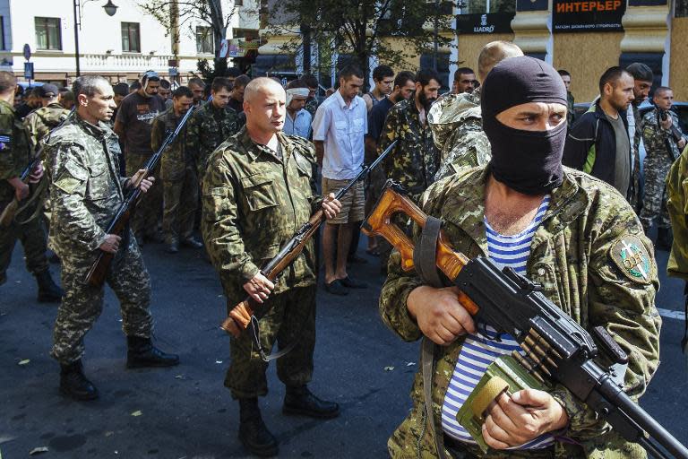 Pro-Russian gunmen guard parade dozens of captured Ukrainian soldiers during a march in mockery of the country's Independence Day celebrations in the main separatist stronghold Donetsk on August 24, 2014