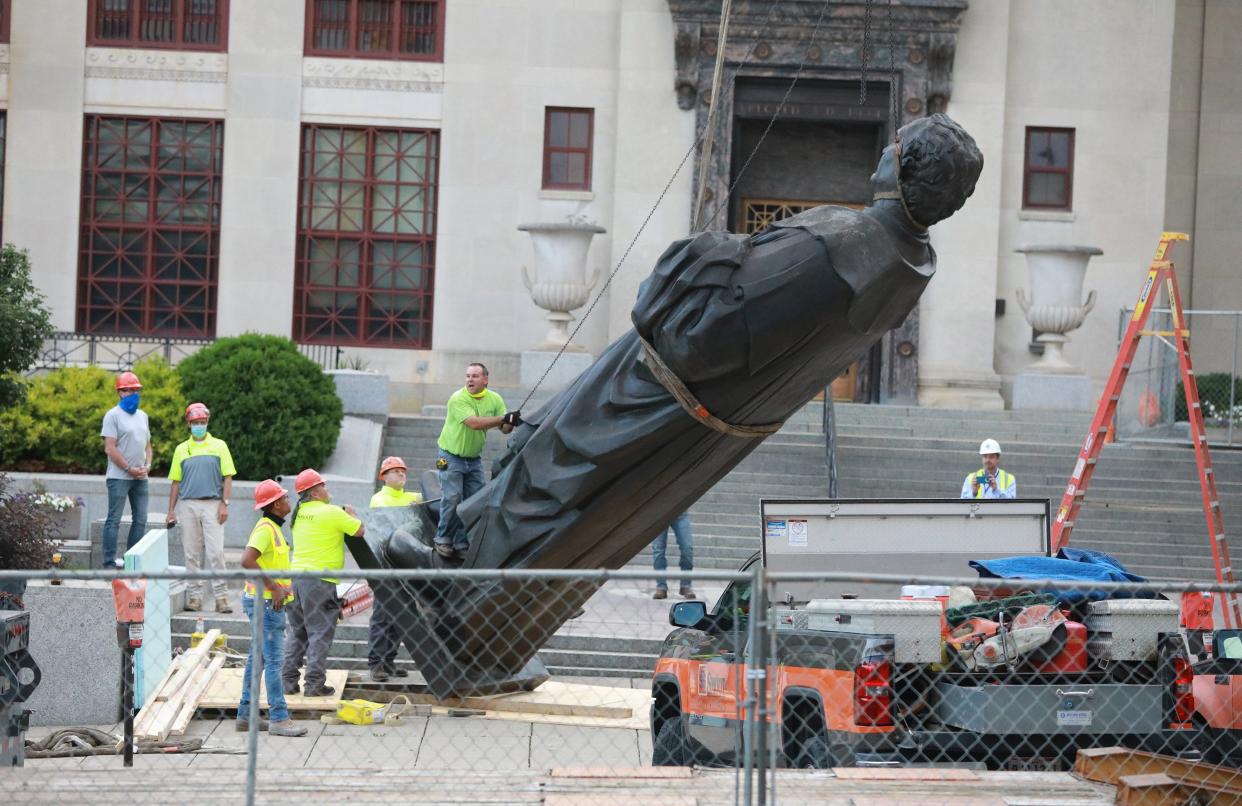 Workers remove the Christopher Columbus statue on the Broad Street side of Columbus City Hall on July 1, 2020.  The statue was a gift from the people of Genoa, Italy, in 1955.