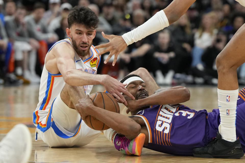 Oklahoma City Thunder forward Chet Holmgren, left, and Phoenix Suns guard Bradley Beal (3) fight for a loose ball during the second half of an NBA basketball game, Sunday, March 3, 2024, in Phoenix. (AP Photo/Rick Scuteri)