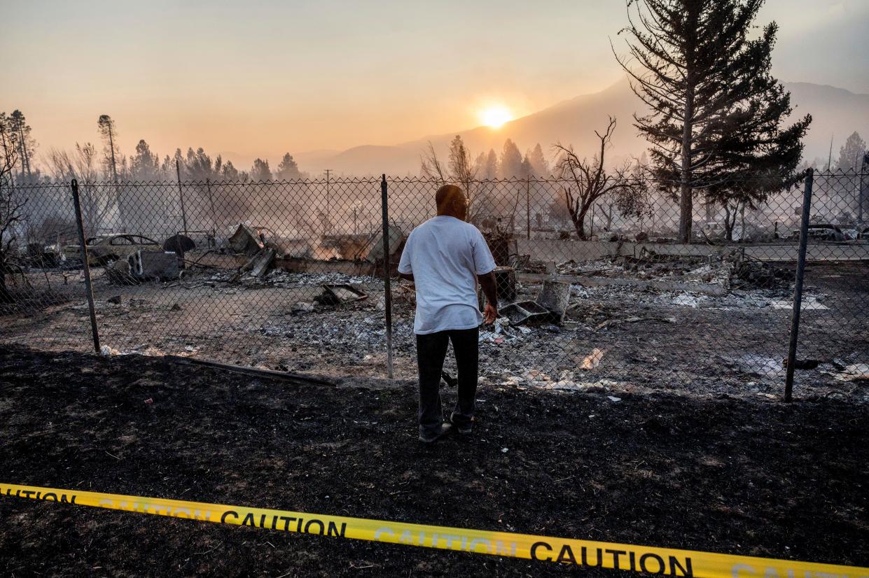 Dave Rodgers surveys his home, destroyed by the Mill Fire, on Saturday, Sept. 3, 2022, in Weed, Calif. Rodgers, who lived in the house his entire life, was able to take an elderly neighbor with him as he fled the fast-moving blaze but has not been able to find his two dogs that were left behind. (AP Photo/Noah Berger)