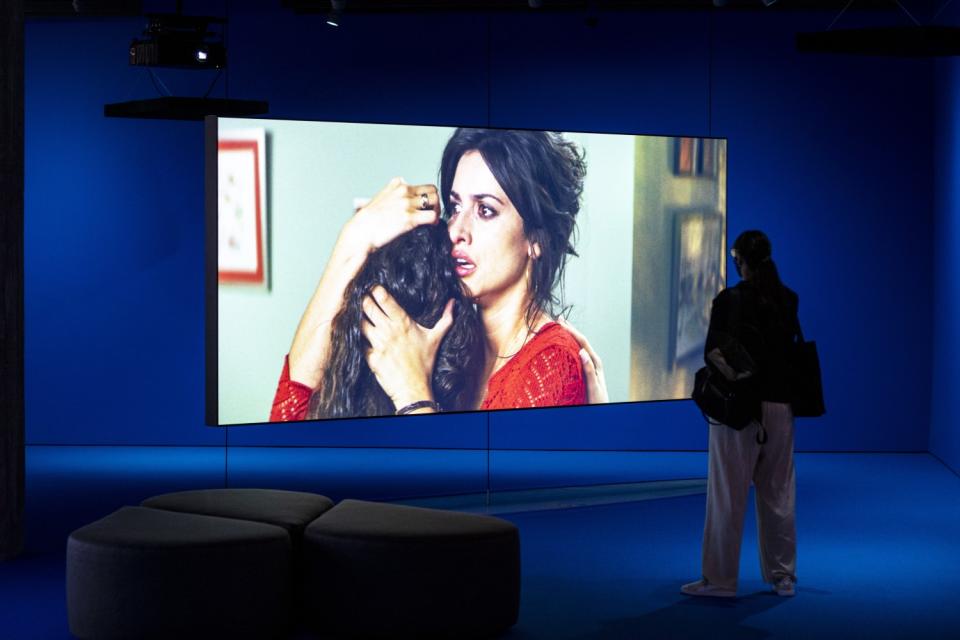 A visitor watches a movie play on a large screen