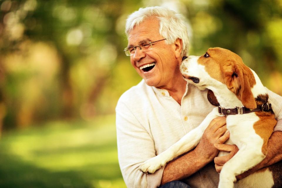 A smiling person holding a dog.