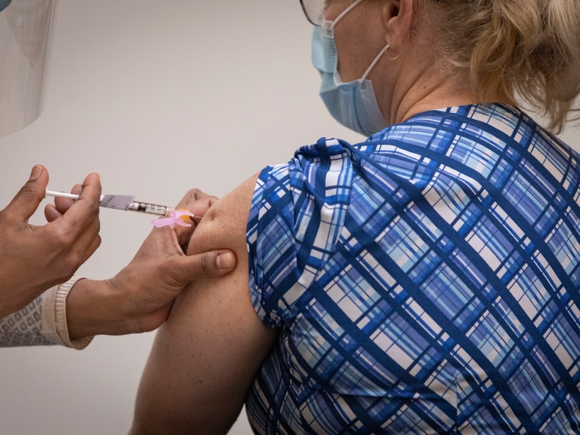 Care home workers get the Pfizer-BioNTech COVID-19 vaccine at a clinic in St. Michael’s Hospital in Toronto on Dec. 22, 2020. Ontario is set to lower the age of eligibility for COVID-19 booster shots to people aged 50 and older, sources say. (Evan Mitsui/CBC - image credit)