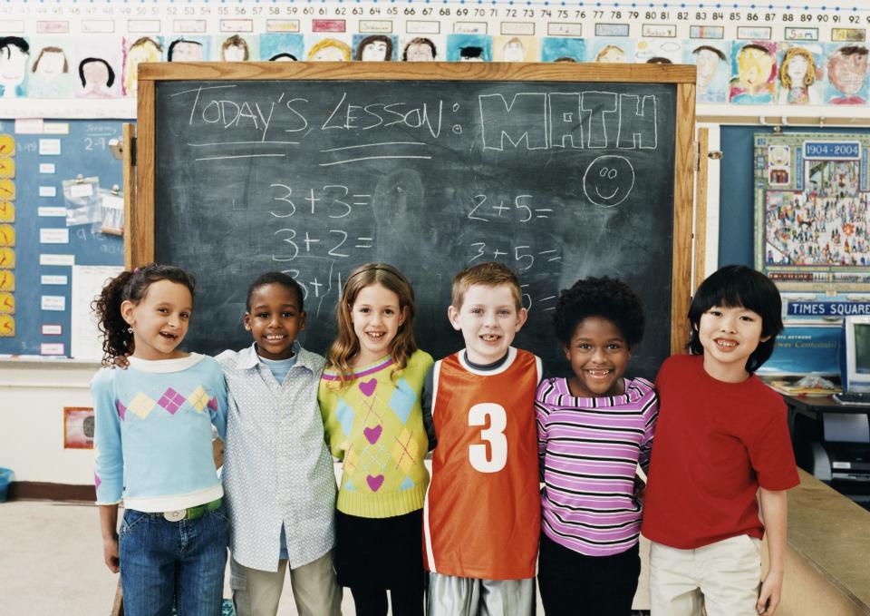 students standing front of a chalkboard with math problems