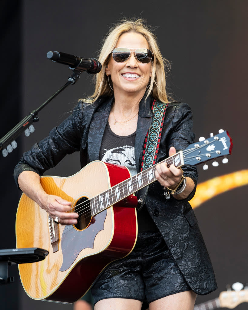 sheryl playing her guitar on stage