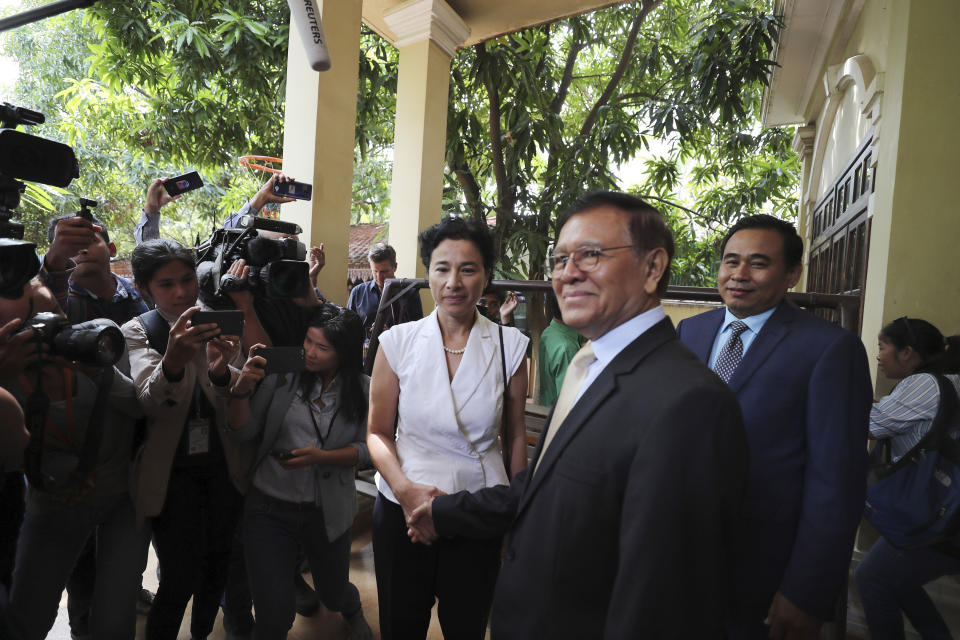 Cambodia National Rescue Party's President Kem Sokha, foreground, shakes hands with French Ambassador to Cambodia Eva Nguyen Binh, center, before a welcome meeting at his house in Phnom Penh, Cambodia, Monday, Nov. 11, 2019. A Cambodian court has lifted some restrictions on detained opposition leader Kem Sokha, essentially ending his house arrest. (AP Photo/Heng Sinith)