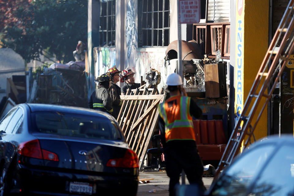 Firefighters stand outside a warehouse after a fire broke out during an electronic dance party late Friday evening, resulting in at least nine deaths and many unaccounted for in the Fruitvale district of Oakland, California, U.S. December 3, 2016. REUTERS/Stephen Lam