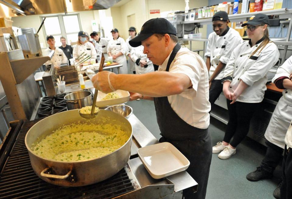 Weymouth High School culinary arts students look on as chef Paul Wahlberg, of Hingham, plates his pea and lemon risotto dish during a cooking demonstration for the students Monday, April 11, 2022.