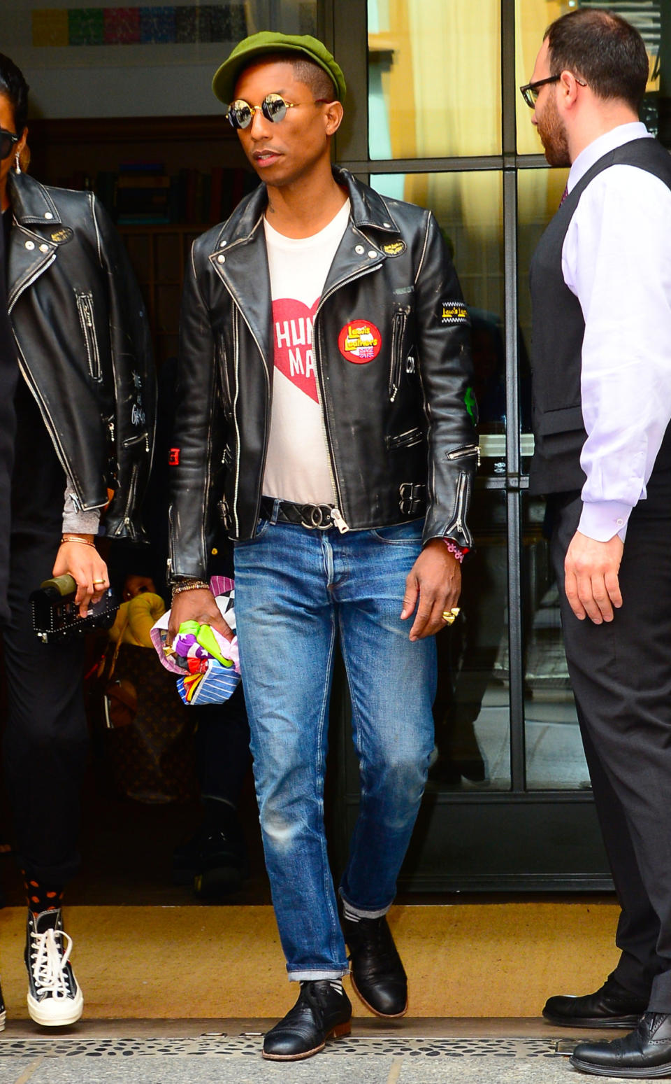 Pharrell Williams in a leather jacket, white T-shirt, jeans, and a Chanel belt.