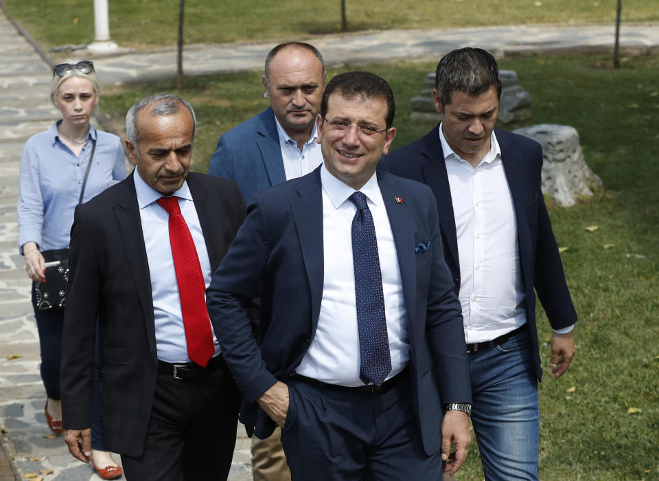 Ekrem Imamoglu, centre, the new Mayor of Istanbul from Turkey's main opposition opposition Republican People's Party (CHP) arrives for a media conference with foreign media a day after he took over office, in Istanbul, Friday, June 28, 2019. Imamoglu said Friday he was prepared against any attempts by the government to restrict his powers while emphasizing his willingness to work with Turkish President Recep Tayyip Erdogan.(AP Photo/Lefteris Pitarakis)