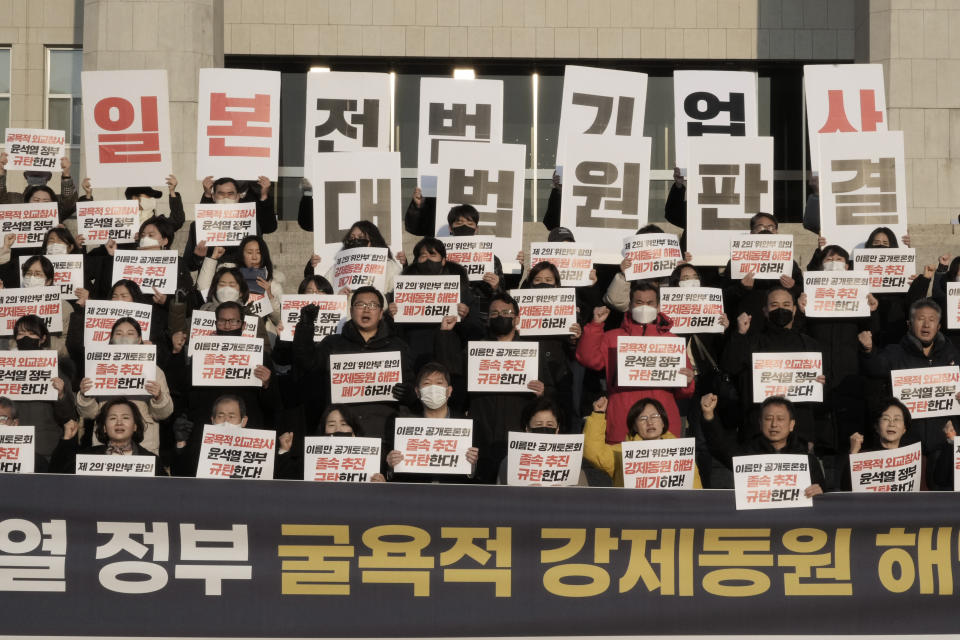 Members of a civic group seeking compensation from Japanese firms over forced labor during World War II and opposition lawmakers stage a rally to oppose the government's reported resolution to the issue outside the National Assembly in Seoul, Thursday, Jan. 12, 2023. The banners read "Apology and compensation from Japanese war criminal companies and condemn the government of President Yoon Suk Yeol." (AP Photo/Ahn Young-joon)