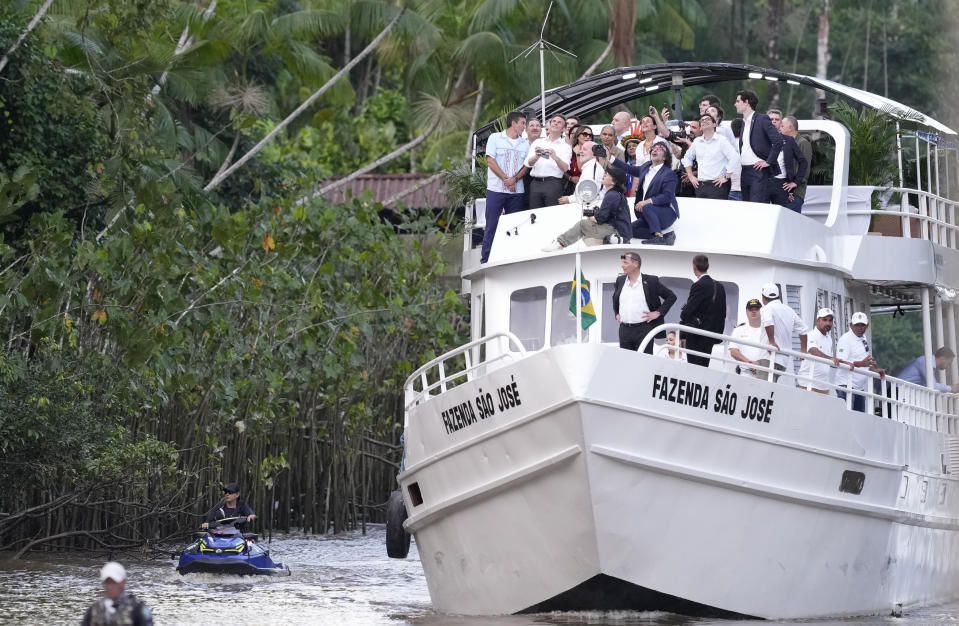 French President Emmanuel Macron, second left, flies a drone, on Combu Island, near Belem, Para state, Brazil, Tuesday, March 26, 2024. Macron is on a three-day official visit to Brazil. (AP Photo/Eraldo Peres)