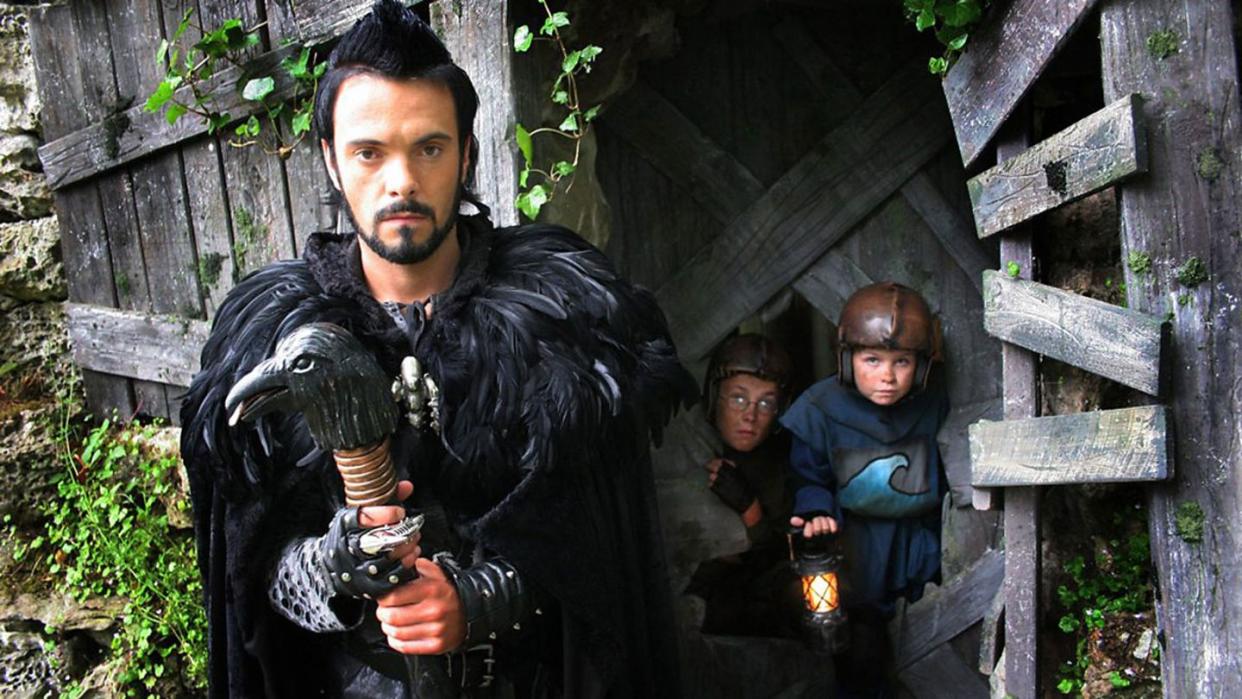 cbbc raven, james mackenzie in black costume with a cape and a bird staff