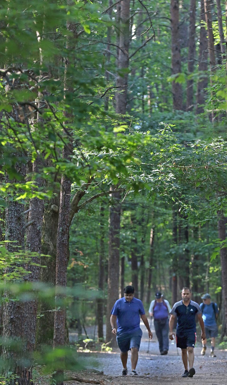 Kenan Patel and P.K.Patel hike the trail with others early Thursday morning, June 16, 2022, at Crowders Mountain State Park.