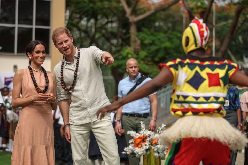 britains prince harry 2nd l, duke of sussex, and britains meghan l, duchess of sussex, look at people dancing as they arrive at the lightway academy in abuja on may 10, 2024 as they visit nigeria as part of celebrations of invictus games anniversary photo by kola sulaimon afp photo by kola sulaimonafp via getty images