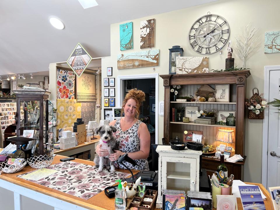 Pamela Sexton, owner of Cattail Cottage, a home decor shop in downtown Southport, greets customers, along with her dog Luna, on Thursday, July 28.