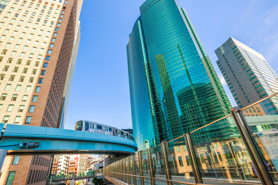 Tokyo, Japan - April 20, 2017: wide angle view of Yurikamome line, an elevated and automatic monorail train and Shiodome City Center facade reflecting. Shiodome skyscrapers in Shimbashi district.