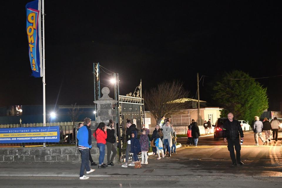 People stand at the entrance to Pontin Brean Sands Holiday Park after the collapse (PA)