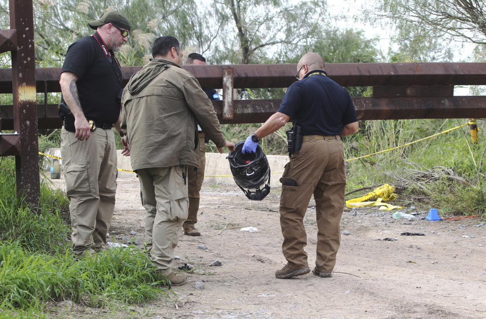 Border Patrol investigators lift the helmet worn by an off duty border patrol agent that was killed near a levee Wednesday Dec. 7, 2022 in Mission, Texas. (Delcia Lopez/The Monitor via AP)