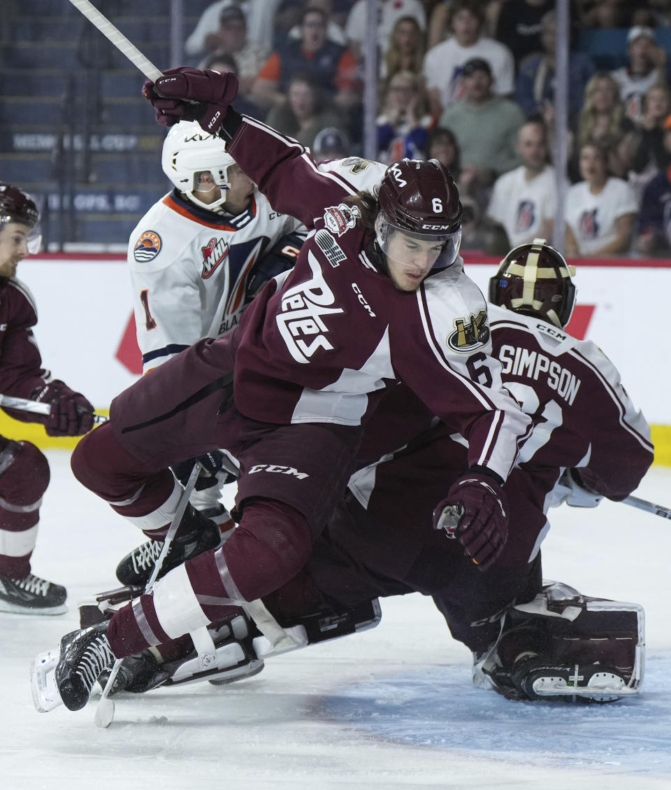Peterborough Petes' Konnor Smith (6) falls over Petes goalie Michael Simpson (31) during first-period CHL Memorial Cup hockey game action against the Kamloops Blazers in Kamloops, British Columbia, Sunday, May 28, 2023. (Darryl Dyck/The Canadian Press via AP)