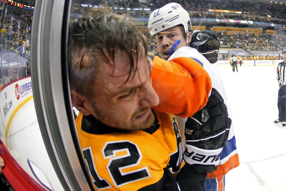 New York Islanders' Matt Martin (17) and Pittsburgh Penguins' Zach Aston-Reese (12) fight during the second period in Game 2 of an NHL hockey Stanley Cup first-round playoff series in Pittsburgh, Tuesday, May 18, 2021. Both players received a two-minute minor penalty. (AP Photo/Gene J. Puskar)