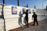 Supporters of Avigdor Lieberman's Yisrael Beitenu party, hang up the party's election campaign posters near a polling station in the Israeli settlement of Nokdim in the occupied West Bank