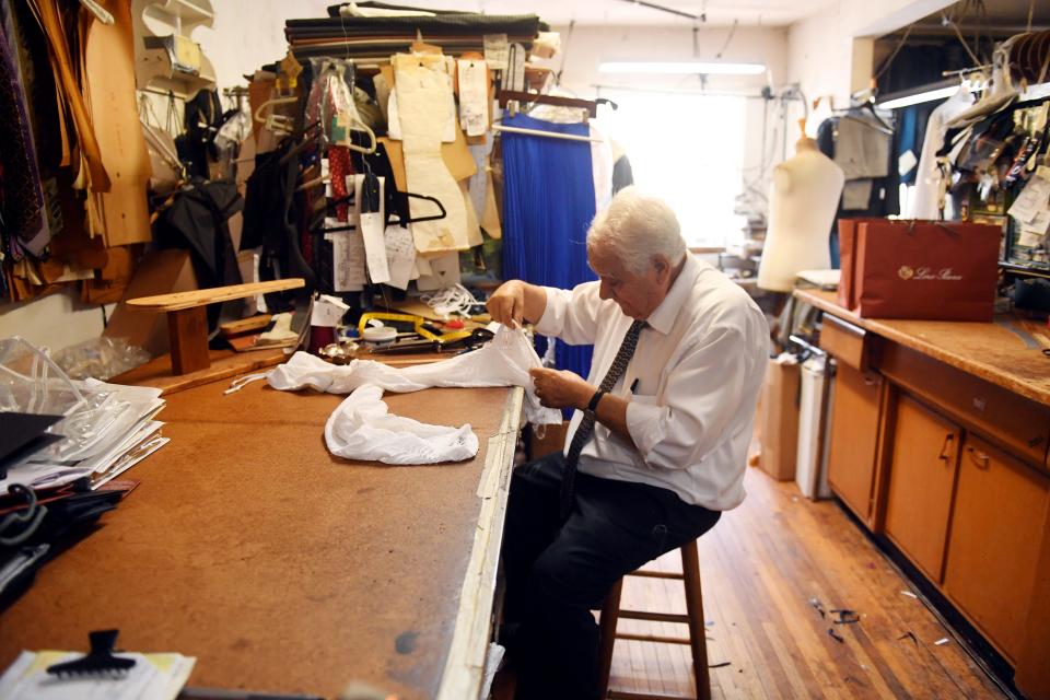 Mario Vita works at his bench in his tailor shop on Harding Avenue in Surfside. "We had clients who died in the collapse," said Vita's wife, Angie Vita. "One day they're standing here in the shop and the next day, gone."